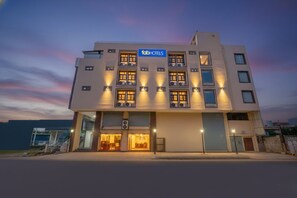 Un hôtel moderne à la façade sobre, doté de nombreuses fenêtres et d’une enseigne indiquant « fabHOTELS ».
