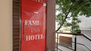 A red door with "FAMILY INN HOTEL" and a crown logo. - Fabhotel Family Inn (Lucknow)