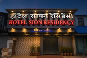 Un letrero de hotel con el nombre 'HOTEL SION RESIDENCY' y el logotipo 'fabHOTELS'.