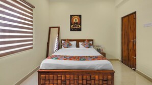 Una camera da letto ordinata con un letto, una testiera in legno, un quadro appeso al muro e una porta.