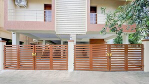 Ingresso recintato di un edificio residenziale, con pavimento in cemento e cancello in metallo.