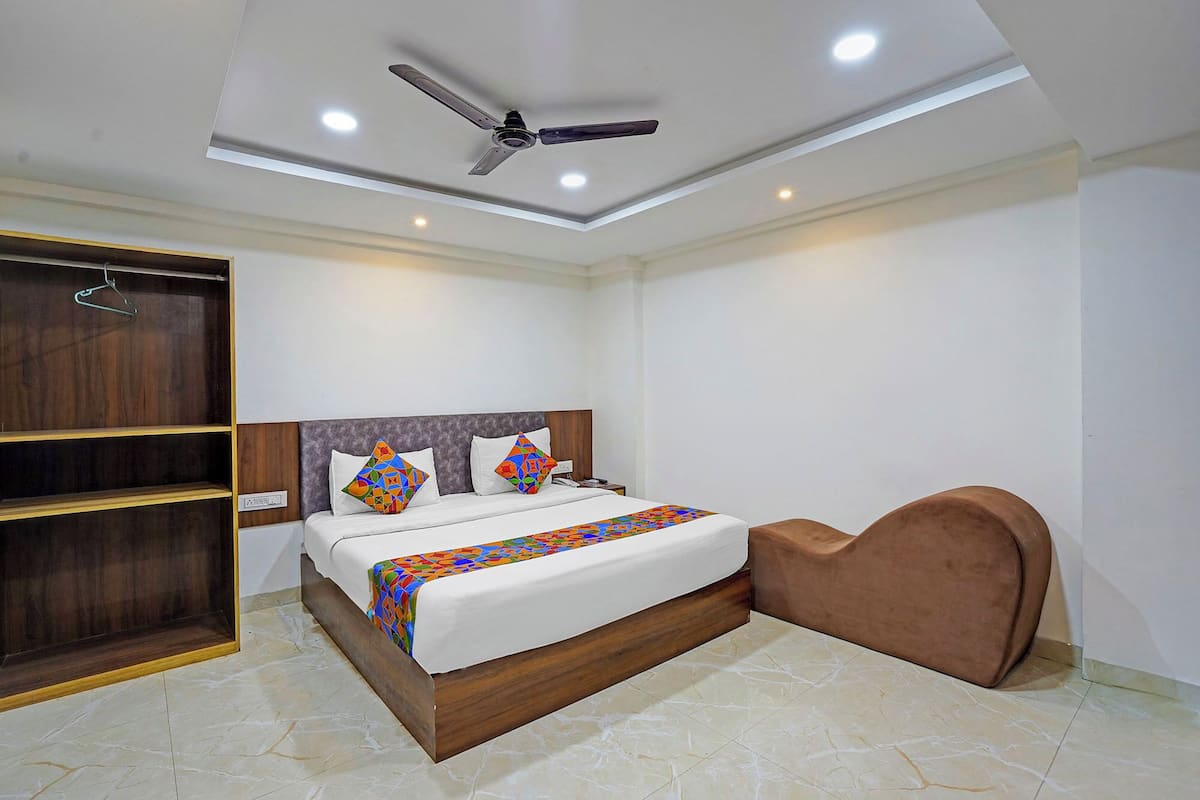 Une chambre à coucher comprenant un lit, une armoire, un ventilateur de plafond et un éclairage encastré.