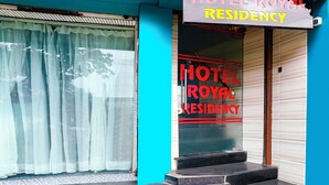 Een hotelentree met een bord waarop 'HOTEL ROYAL RESIDENCY' staat.