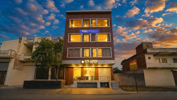 Un hotel moderno con un cartel que dice "fabHOTELS" y "HOTEL SUNSHINE".