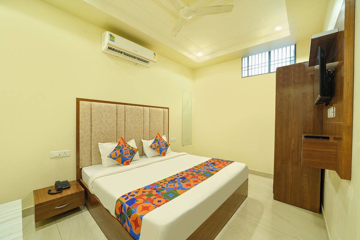 Una habitación de hotel con cama, mesita de noche y armario.