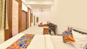 A hotel room with a bed, a desk, a chair, and a mirror. - FabHotel Shree Radhey Shyam Palace - 500m Khatushyam Temple Khatoo (Khatoo)