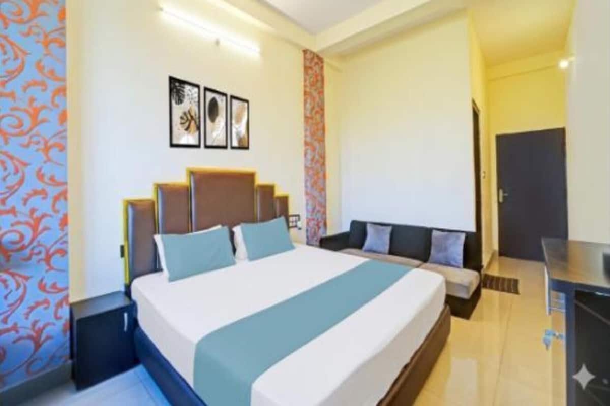 Een hotelkamer met een groot bed, een nachtkastje, een stoel en een bureau.