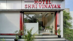 The exterior of Hotel Shri Vinayak with a modern facade, glass entrance, and potted plants in front. - Fabhotel Shri Vinayak (Bhopal)