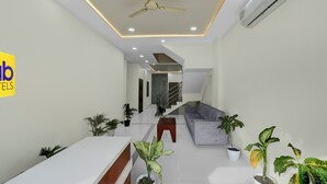 A modern hotel lobby with a reception desk, seating area, and staircase leading to upper floors. - Fabhotel Shri Vinayak (Bhopal)