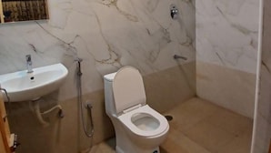 Kylpyhuone, jossa on valkoinen pesuallas, wc ja suihku.