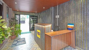 Un comptoir d’accueil avec une enseigne « Tab Hotels », une plante en pot et un tableau accroché au mur.