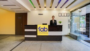 Una mesa de recepción con un cartel que dice "fab hotels" y una recepcionista.