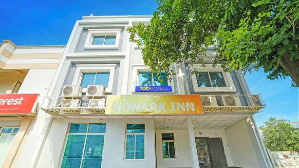 Un hôtel avec une enseigne indiquant « Konark Inn » et « Tab Hotels ».