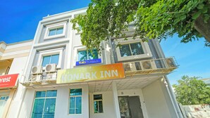 Un hôtel appelé « Konark Inn », doté d’une façade moderne, de grandes fenêtres et de climatiseurs.