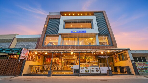 A modern building with a 'fabHOTELS' sign, featuring a large glass storefront and a covered outdoor seating area. - Fabhotel Shri Shreeyam Stay (Bhopal)