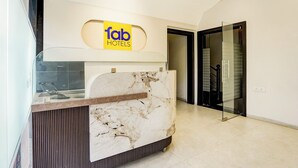 A reception desk with a marble top and a sign above it that reads "fab HOTELS". - Fabhotel Cosmos Green (Indore)