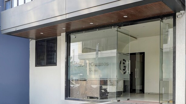 A modern building entrance with glass doors and a sign reading "Cosmos Green." - Fabhotel Cosmos Green (Indore)