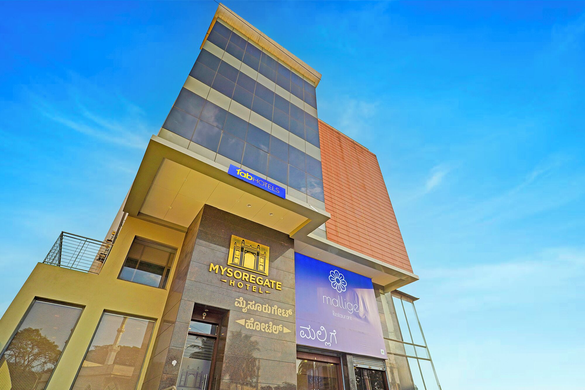A hotel with a modern design, featuring a prominent glass facade and signage for 'Tab Hotels'.