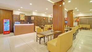 A hotel lobby with a reception desk, seating area, and a Coca-Cola refrigerator. - FabHotel New Mysore Gate (Bengaluru)