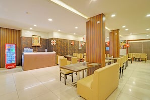 A hotel lobby with a reception desk, seating area, and a Coca-Cola refrigerator. - FabHotel New Mysore Gate (Bengaluru)
