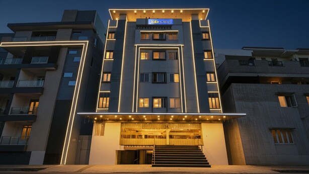 Een modern hotel met een centrale ingang, verschillende verdiepingen en een opvallend bord.