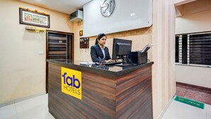 A reception desk with a sign reading "fab HOTELS". - Fabhotel Pride Image (Bangalore)