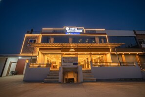 A modern hotel with a prominent entrance, a covered area, and a sign indicating it is a 'Hotel Super Corridor' by FabHotels. - Fabhotel Super Corridor (Indore)