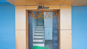 Entrada de hotel con un letrero de 'Welcome', una escalera y una alfombra verde.