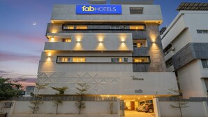 Un hotel moderno de varios pisos con un llamativo letrero de 'fab hotels'.