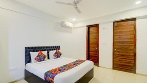 Un dormitorio con cama, ventilador de techo y dos puertas de madera.