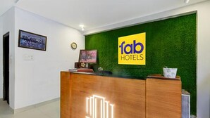 A reception desk with a green wall and a 'fab hotels' sign. - Fabhotel Jaswitha Grand (Hyderabad)