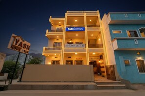 Egy többemeletes épület, amelyen a „fabHOTELS” és a „YASH STAY IN” felirat látható.
