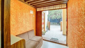 A room with a wooden ceiling, a sofa, and a patterned floor. - Fabhotel Yash Stay Inn (Bhopal)