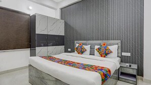 A modern bedroom with a large bed, a wardrobe, and a nightstand. - Fabhotel Kashi (Varanasi)