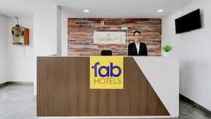 A reception desk with a wooden panel design, a sign for 'High Risee Hotel', and a 'fab Hotels' logo. - Fabhotel High Rise Near Airport (Hyderabad)