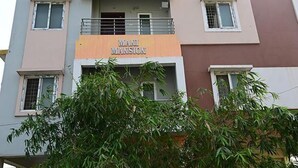 Un edificio de varios pisos con un letrero que dice "MANI MANSION".