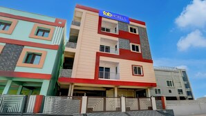 A multi-story building with a 'fabHOTELS' sign, featuring a modern architectural design with geometric patterns and a mix of colors. - Fabexpress Coastal Suites (Kakinada)