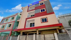 A multi-story hotel with a prominent 'fabHOTELS' sign, a modern facade, and a gated entrance. - Fabexpress Coastal Suites (Kakinada)