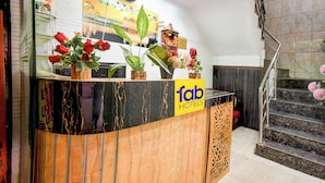 A hotel reception desk with a marble design, a clock, and a staircase in the background. - Fabhotel Park Avenue (Lucknow)