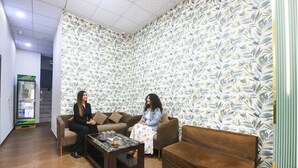 A room with two sofas, a coffee table, and a patterned wallpaper. - Fabhotel Canal View (Ludhiana)