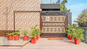 A gated entrance with a 'No Parking' sign, a brick wall, and potted plants. - Fabhotel Winsome Inn (Noida)