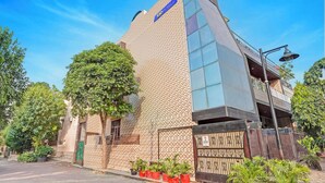 A hotel with a distinctive brick facade and a large glass window. - Fabhotel Winsome Inn (Noida)