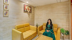 A modern living room with a yellow sofa, a matching armchair, and a coffee table. There is a framed picture on the wall and a potted plant on the side. - Fabhotel Dsg Residency (Faridabad)