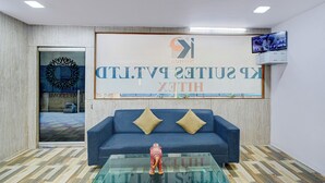A reception area with a blue sofa, two gold cushions, a glass coffee table with a decorative elephant, and a large sign reading "King Suites". - Fabhotel Vsm Suites (Hyderabad)