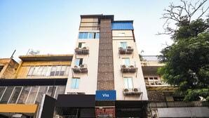 A multi-story building with balconies, a sign for 'Malk House,' and a 'Via' sign. - Via Red Apple Greater Kailash (New Delhi)
