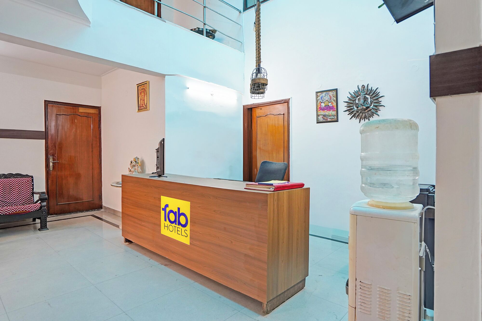 Una recepción con un logo, un dispensador de agua y una silla.