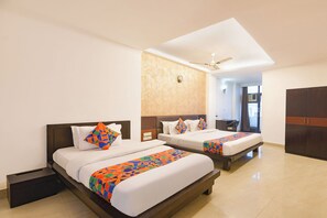 A hotel room with two beds, a ceiling fan, and a large window. - Fabhotel Golden Palm (New Delhi)