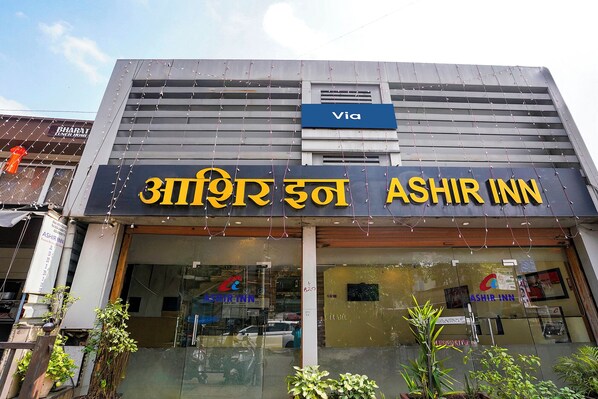 Un hôtel appelé « Ashir Inn », avec une enseigne bien visible et un panneau « Via » au-dessus.