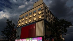 A multi-story hotel with a flat roof and a large red awning. - Fabhotel D Grand (Madurai)