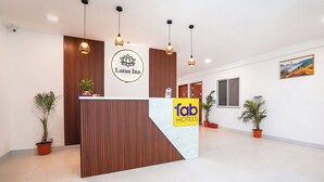 A reception desk with a wooden panel design, a 'Lotus Inn' sign, and 'Fab Hotels' branding. - Fabhotel Lotus Inn Pimpri Chinchwad (Pune)